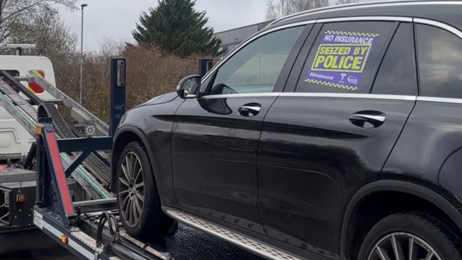 Seized black car being towed away for no insurance.