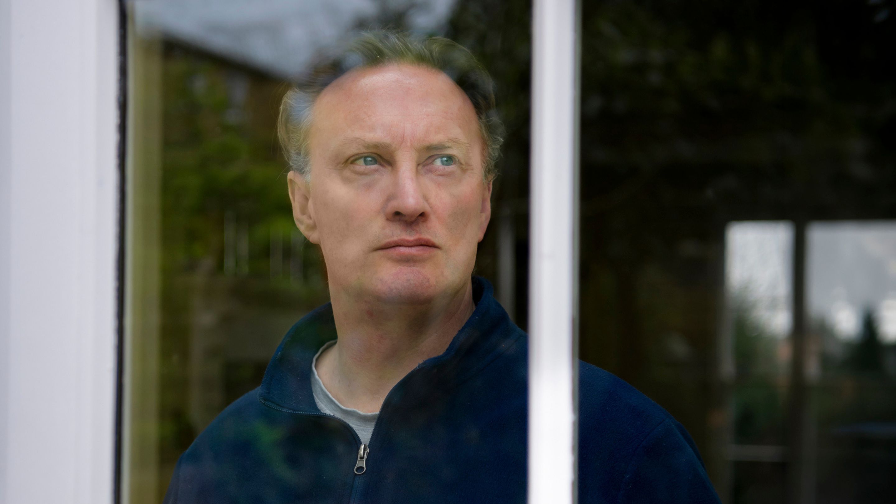 A man looking through a window.